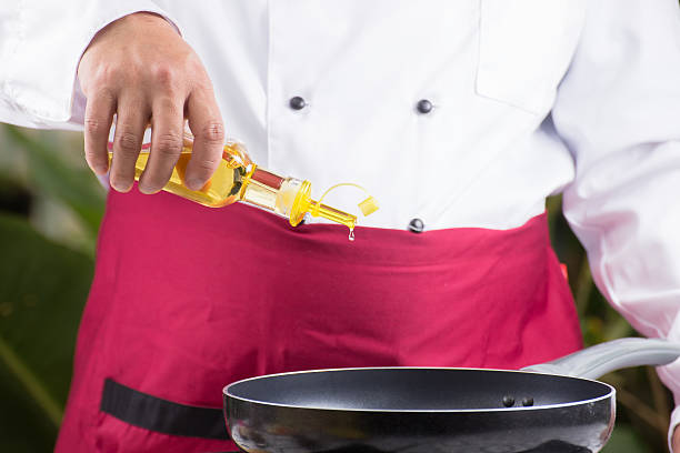 istock Chef pouring vegetable oil to the pan 612265488