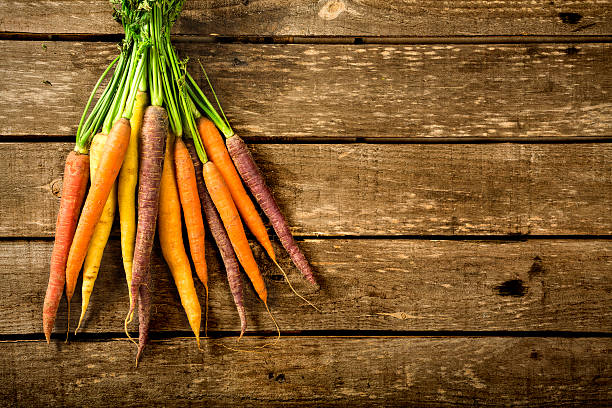istock Bunch of carrots on a wooden table with copy space 612266686