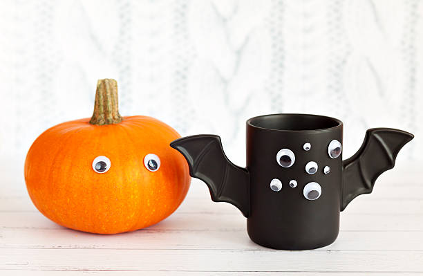 istock cup of coffee like bat with eyes on Halloween white 612266904