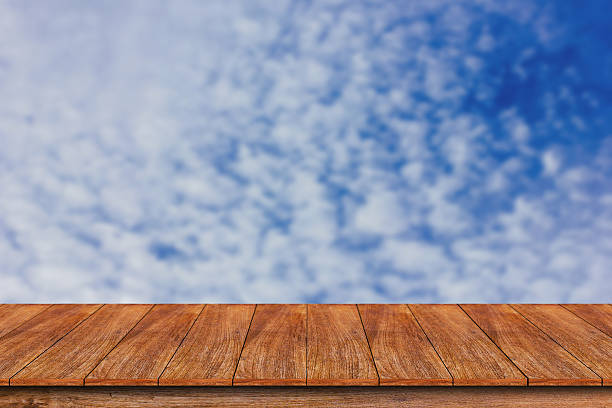 istock Wood table top on blurred blue sky background 612267902