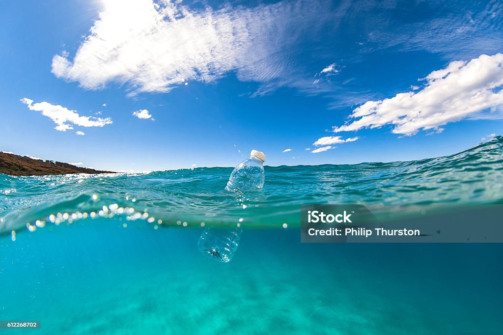 Bottiglia di plastica galleggiante sulla superficie dell'oceano - Foto stock royalty-free di Mare