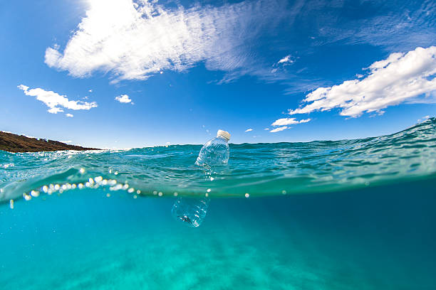 floating plastic bottle on ocean surface - sustainable resources environment education cleaning imagens e fotografias de stock