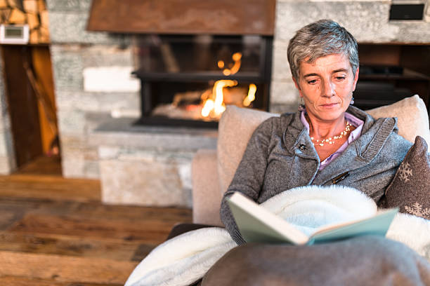 istock woman reading a book on the couch 612269434