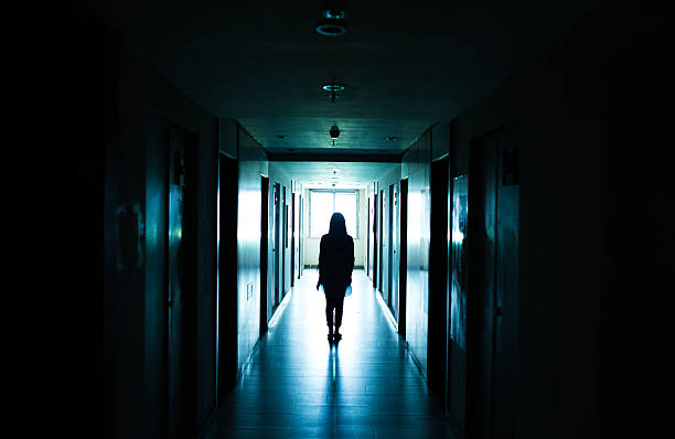 istock young woman walks alone in a dark tunnel 612368936