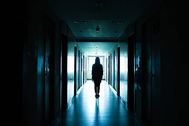 istock young woman walks alone in a dark tunnel 612368974