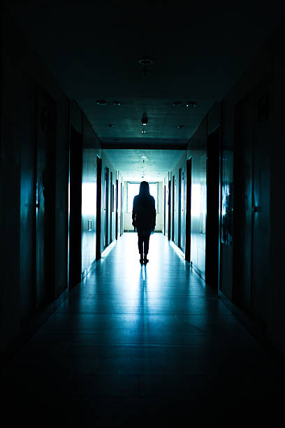 istock Young woman standing alone in a dark tunnel 612369020