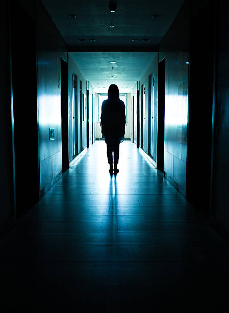 istock Young woman standing alone in a dark tunnel 612369064