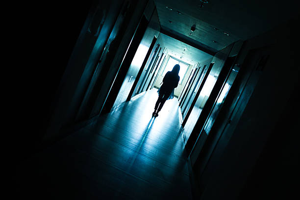 istock Young woman standing alone in a dark tunnel 612369134