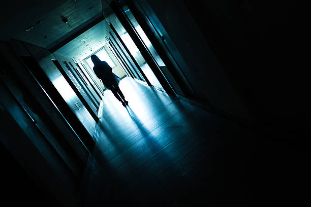 istock Young woman standing alone in a dark tunnel 612369208