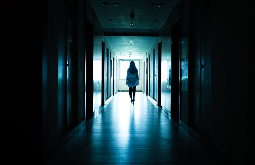 Young woman standing alone in a dark tunnel