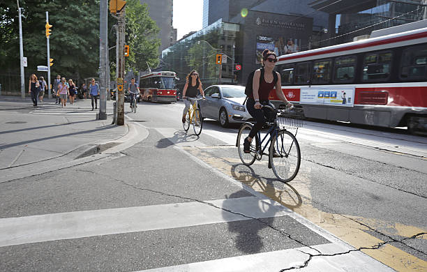 Toronto, Canada - August 17, 2016: Traffic on Queen Street, Toronto, Canada in Summer. Cyclists, pedestrians and vehicles share 100-block Queen Street West, Grange Park neighbourhood downtown. 