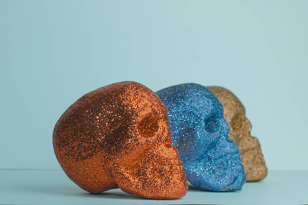 Side profile of orange and blue human skull heads 
