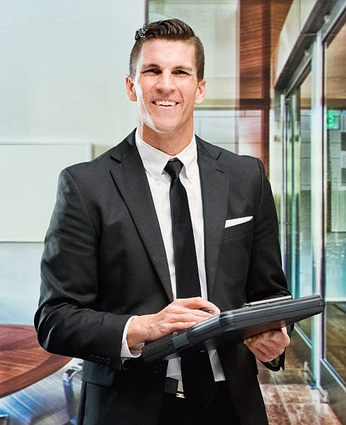 istock Smiling businessman standing in office 612377176