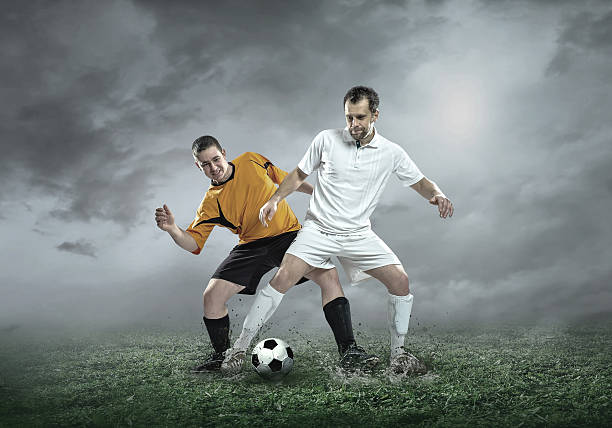 istock Football player with ball in action under sky with clouds 612379122