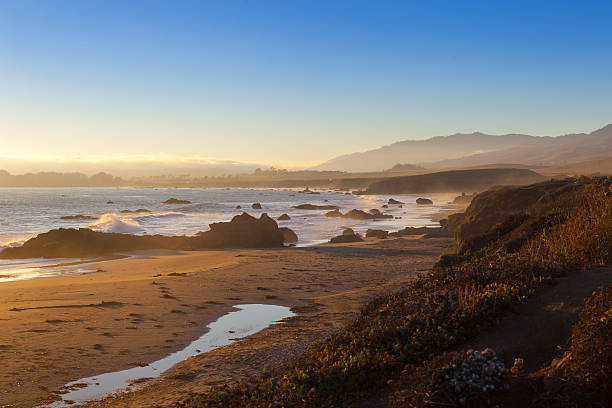 strand bei sonnenuntergang, san simeon, kalifornien, vereinigte staaten von amerika - san simeon stock-fotos und bilder