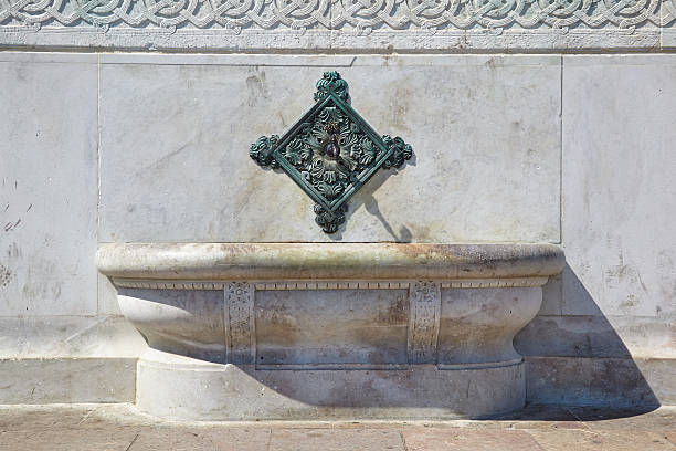istock The brass fountain spouts over basins on the side 612380846