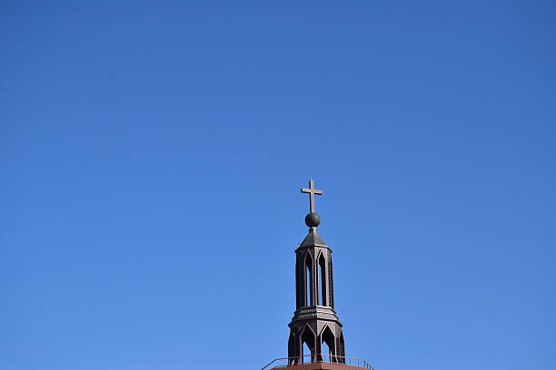istock cross on the roof isolated on blue background. 612382490