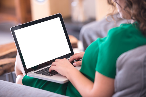 Woman using blank white sceen laptop computer.