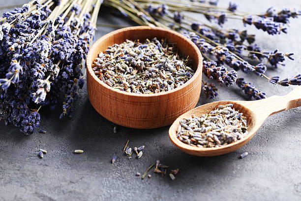 istock Lavender flowers in bowl and spoon on grey table 612382844