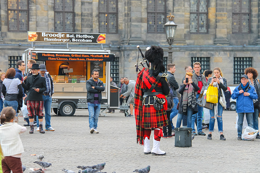 Amsterdam, the Netherlands - October 3, 2015: Male playing Scottish traditional pipes in historic city centre