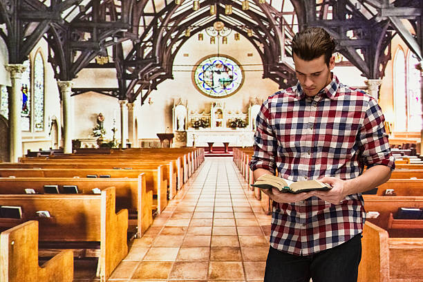 istock Man reading bible in church 612383388