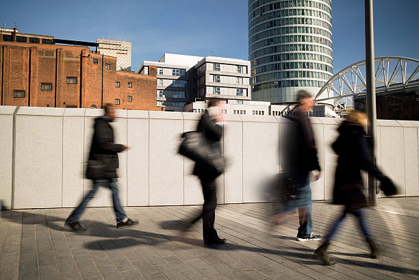 Motion blurred people walking on a city pavement. stock photo