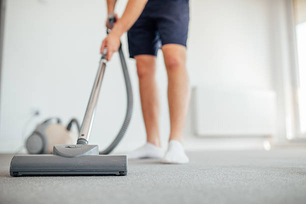 Man is vacuuming. Home floor. stock photo