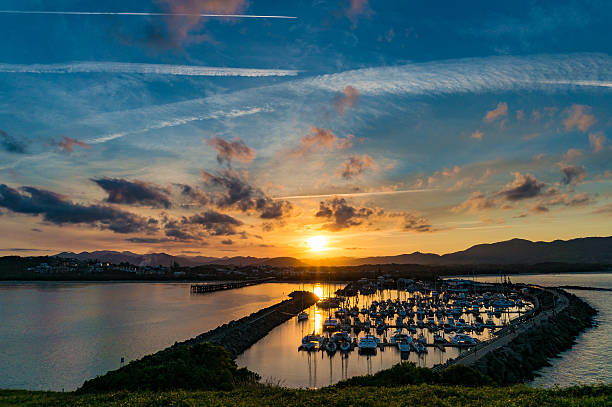Dramatic sky over Coffs Harbour, Australia Sunset landscape of coastal city with dramatic clouds and plane trails on the background. Muttonbird Island Nature Reserve, Coffs Harbour, Australia coffs harbour stock pictures, royalty-free photos & images