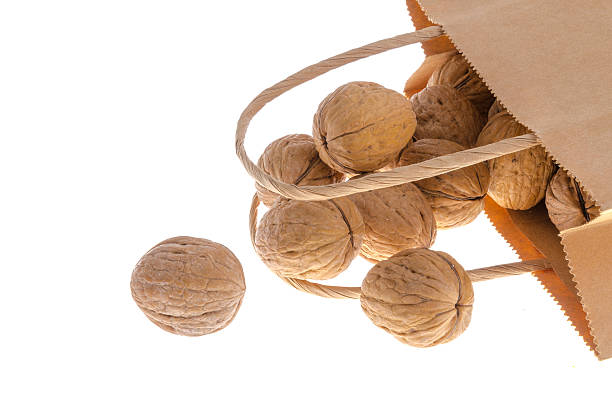 istock Group of closed walnuts in a bag on white background 612388346