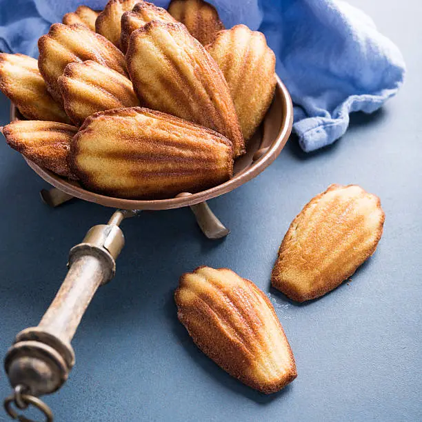 Homemade anise Madeleine cakes on blue background. Holidays food. Copy space for text.