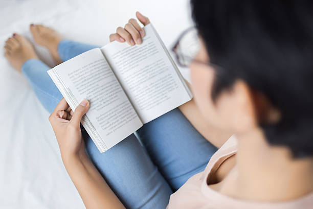 istock Woman reading a good book while on her bed 612389370