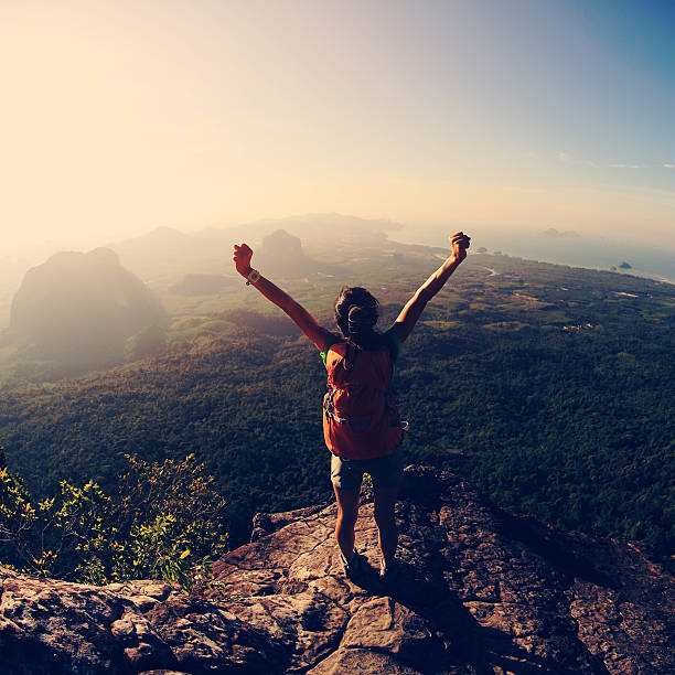 istock young successful woman hiker open arms on mountain peak 612390980
