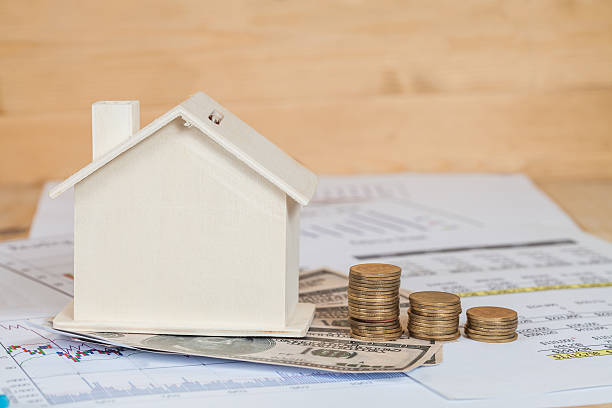 istock Miniature house with money and chart 612391194
