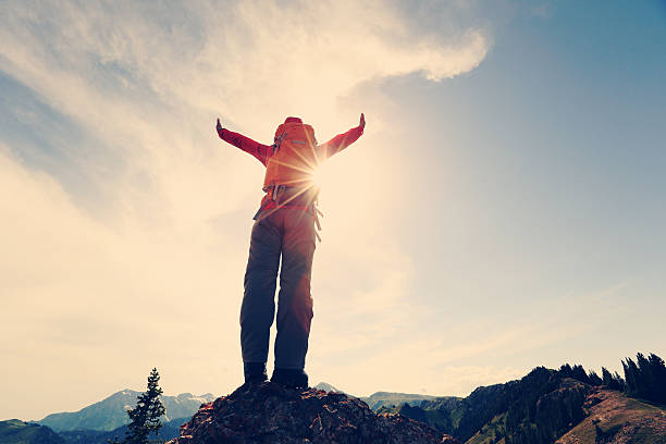 istock successful woman backpacker enjoy the view on mountain peak cliff 612393748