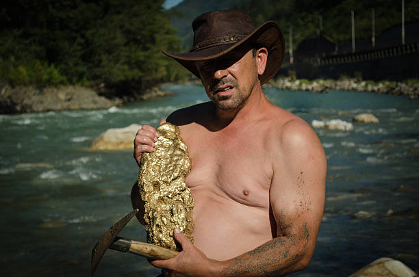 Gold Nugget mining from the River Gold Nugget mining from the River, with a gold pan, and find some big gold nugget. gold mining panning stock pictures, royalty-free photos & images