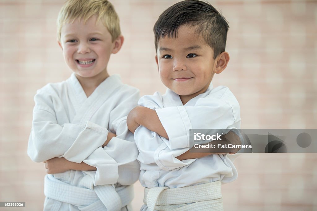 Little Boys Taking a Karate Class Two little boys are taking a karate class  at a health club. They are standing together in their uniforms. Child Stock Photo