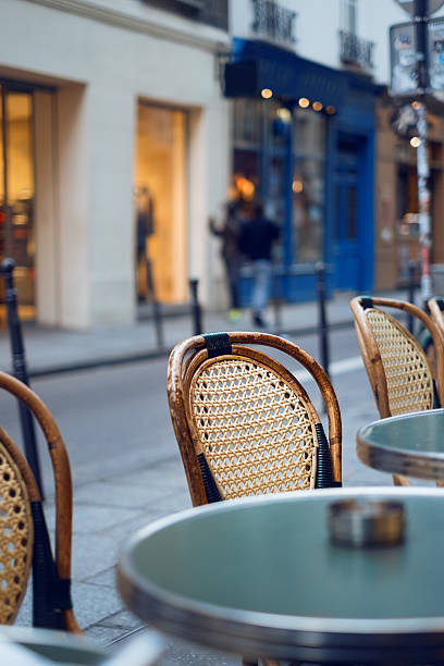 istock Tables and chairs in Paris cafe 612396486