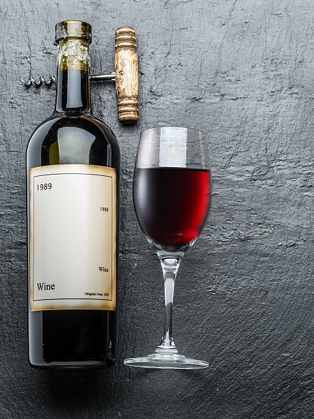 istock Wine bottle, wine glass and corkscrew on the graphite board. 612397034
