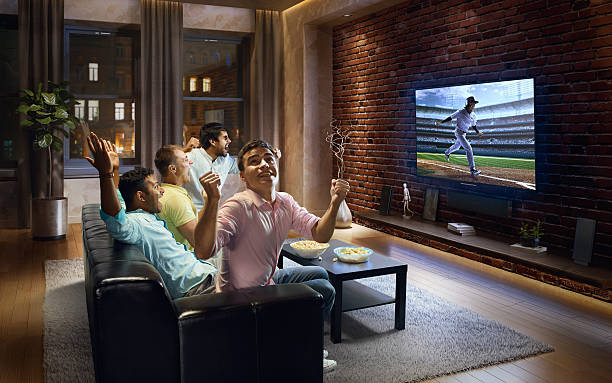 istock Young men cheering and watching Baseball game on TV 612397886