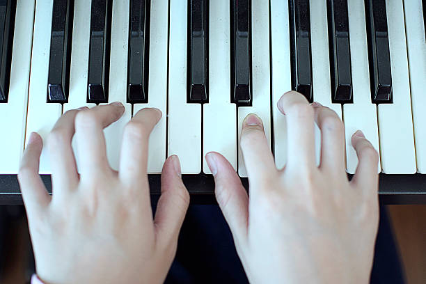 istock Selective focus girl hands playing piano 612398864