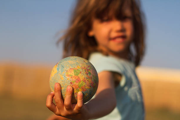 kind hand hält eine erde spielzeug globus - globe earth world map human hand stock-fotos und bilder