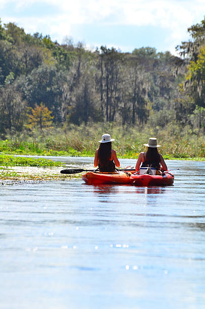 istock Two kayaking teenage girls drifting though natural setting 612399570