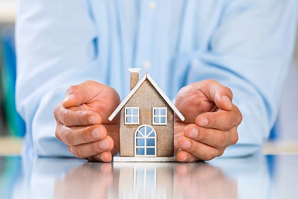 istock Male hands saving Miniature House 612401120