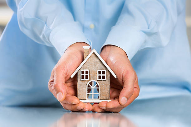istock Male hands saving Miniature House 612401332