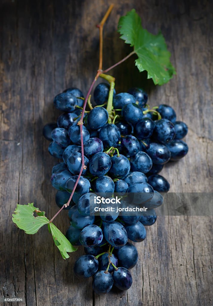 Bunch of red grapes on wooden background Bunch of red grapes on wooden table background Blue Stock Photo