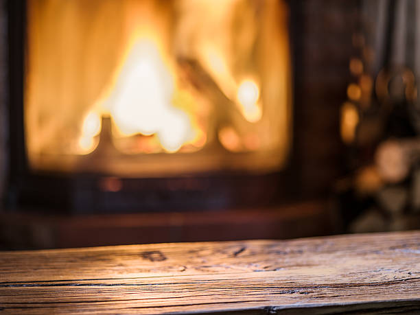 istock Old wooden table and fireplace on the background. 612407386