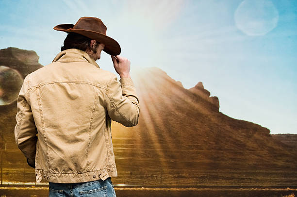 istock Cowboy standing in front of hill 612410552