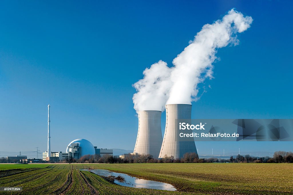 Nuclear power station Grohnde with steaming cooling towers Nuclear power station countryside with two steaming cooling towers and blue sky.  Nuclear Power Station Stock Photo