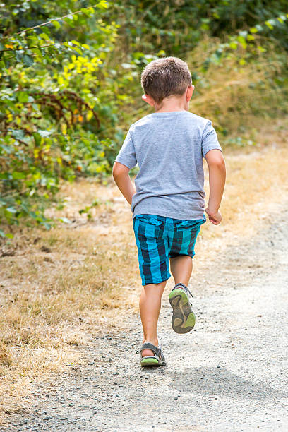 istock child running along a country road 612412434