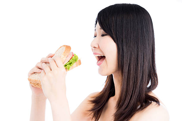 istock Woman eating a BLT sandwich 612414920